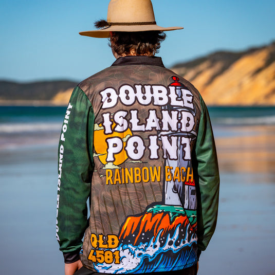 Person wearing a colorful jacket with 'Double Island Point Rainbow Beach' text on a beach.