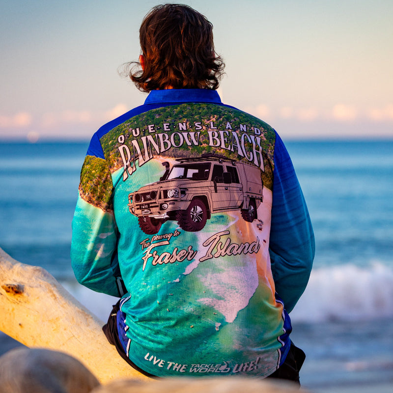 Load image into Gallery viewer, Person wearing a colorful shirt with a graphic design sitting on a beach.